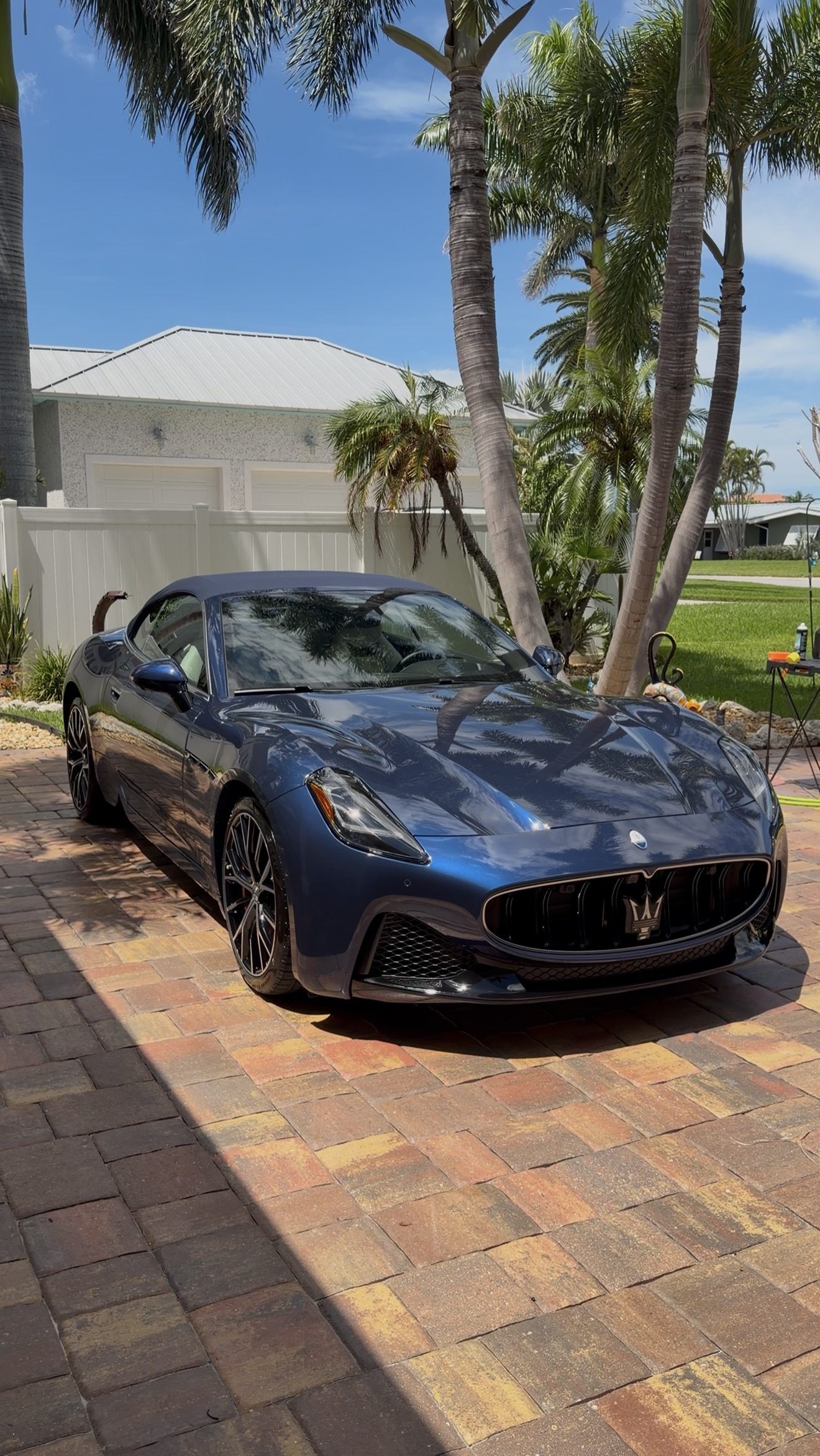 Blue Maserati GranCabrio with a deep, glossy finish after a detail by Harn Detailing Co., on a palm-lined Pinellas County driveway